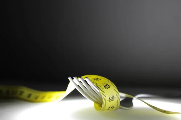 Photo Iron Fork Measuring Tape Passing Its Teeth Symbolize Diet — Stock Photo, Image