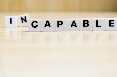   Beceri ve beceri edinme kavramını temsil eden, kelime oluşturan harfleri içeren bir sıra küçük beyaz plastik karo..