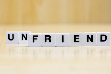 Bir arkadaş edinme ya da kaybetme kavramını temsil etmek için, arkadaş kelimesini oluşturan harfleri içeren bir sıra küçük beyaz plastik karo..