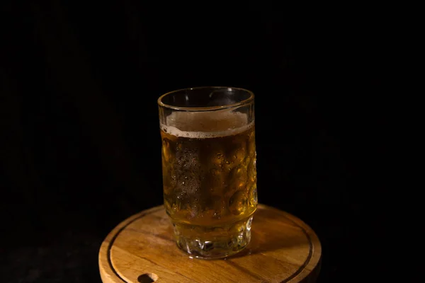 黒を基調としたビールが泡のあるガラスになり — ストック写真