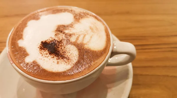 Italian Cappuccino with latte art on wooden background. Beautiful ceramic cups.