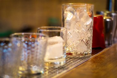 Bardağın üzerinde duran buzlu bir bardak ve birkaç boş bardak. Boşluğu kopyala