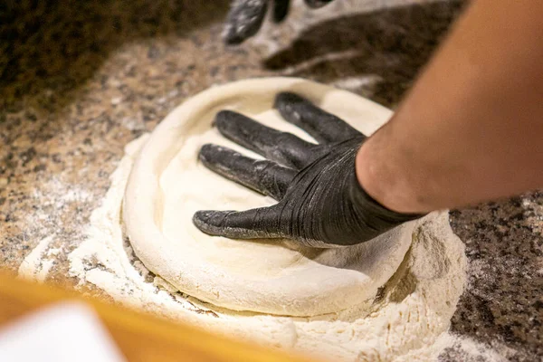 pizza chef kneads pizza dough in gloves. copy space