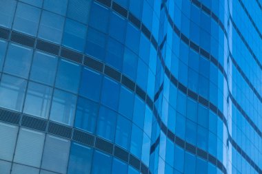 the glass facade of the building reflects the blue sky. financial centers. Background. Wallpaper