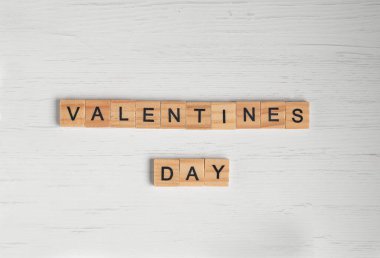 Sevgililer günü sözcüğünün üst görüntüsü eski beyaz ahşap arka plandaki kare ahşap fayanslardan serili..