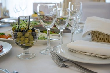 Masanın üzerinde açık renkli tabaklar ve beyaz masa örtüsü ile bir parti, düğün ya da diğer özel bir etkinlik için çeşitli yemekler var. Restoran işletme ve hizmet sektörü kavramı.