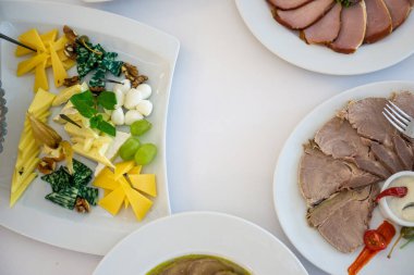 Masa açık renkli tabaklar ve farklı peynirler ile parti, düğün ya da diğer özel etkinlikler için beyaz masa örtüsü olan bir masada. Restoran işletme ve hizmet sektörü