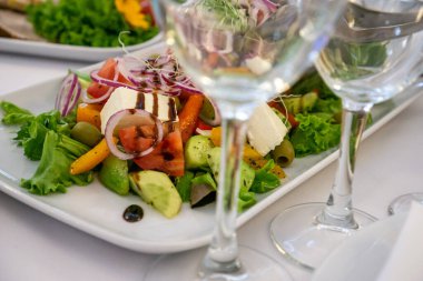 Masanın üzerinde açık renkli tabaklar ve beyaz masa örtüsü ile bir parti, düğün ya da diğer özel bir etkinlik için çeşitli yemekler var. Restoran işletme ve hizmet sektörü kavramı.