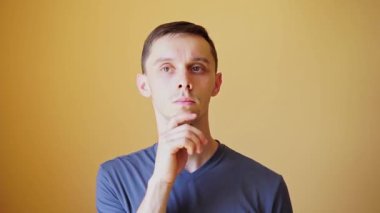 Turuncu tişörtlü, beyaz kökenli, gri tişörtlü, beyaz kökenli genç bir adam bir sorun üzerinde düşünür ve bir çözüm bulur. Sorun çözme kavramı