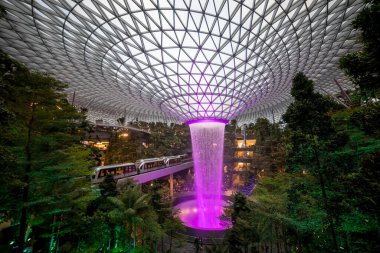 SINGAPORE - 3 Mart 2020 'de Changi Havaalanı, Singapur' un dördüncü terminalindeki alışveriş merkezinde bir şelale. Suda ışık gösterisi.