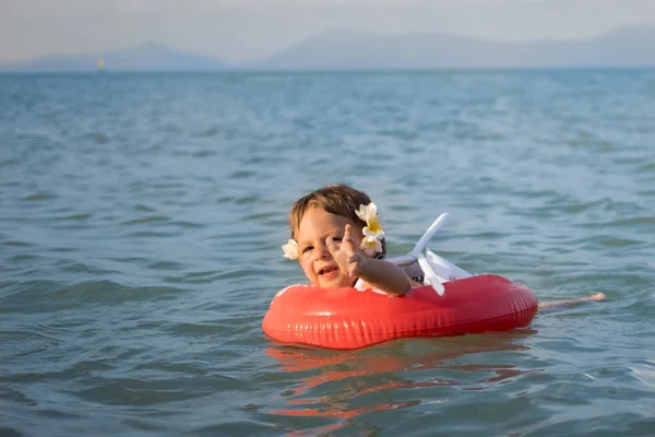 休暇中に危険よ 愛らしい幼児は海の中で特別なインフレータブルリングで一人で泳ぐ — ストック写真