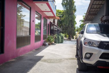 Güneşli bir günde sessiz bir cadde ve park etmiş bir araba. Asya köyü.