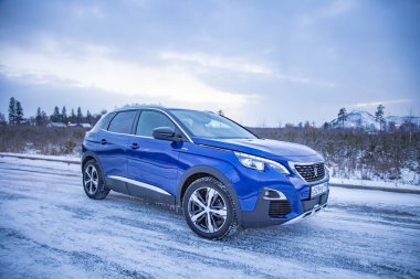 MOSCOW, RUSSIA - MARCH 15, 2020: side view of Blue SUV Peugeot 3008 on on winter countryside landscape clipart