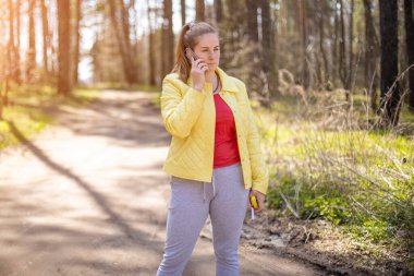 Kadın ormanda telefonda duygusal bir konuşma yapıyor. 5g hücresel iletişim konsepti