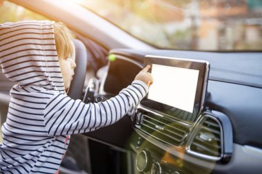 Meraklı küçük kız bir arabayı tutuyor, dokunuyor ve dokunmatik ekran oynatıcı düğmesine basıyor. boş beyaz ekran