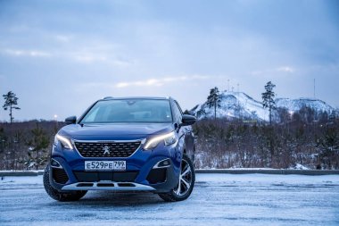 MOSCOW, RUSSIA - 15 Mart 2020: Kış manzarasında Mavi SUV Peugeot 3008 'in ön görüntüsü. Işıklar yanıyor.