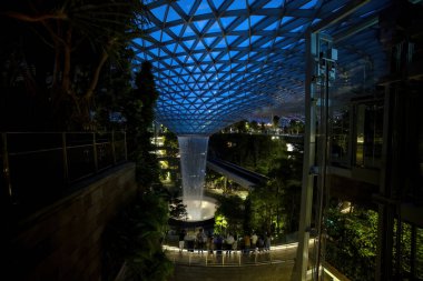 SINGAPORE, SINGAPORE - 4 Mart 2020: Yeni alışveriş merkezi Jewel 4 Changi terminalinin en üst katındaki kapalı parktaki büyük şelale gecesinde ışık gösterisi