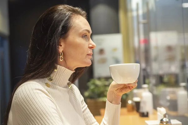 portrait of beautiful woman drinking coffee at a bar in a cafe