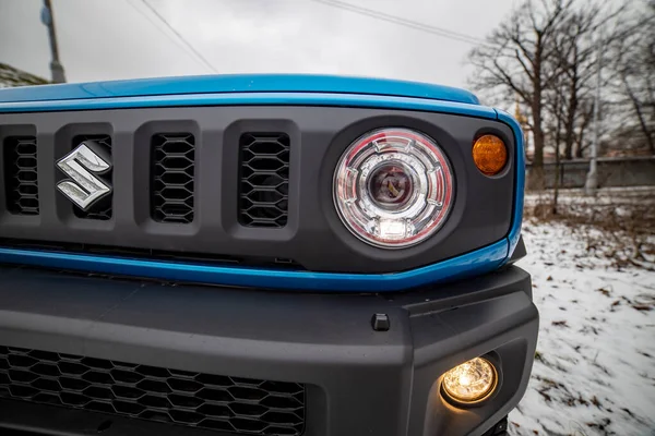 MOSCOW, RUSSIA - JANUARY 24, 2020: Headlight headlamp of new mini SUV Suzuki Jimny Static Photos in winter forest. new design of compact SUV Suzuki Jimny close-up..