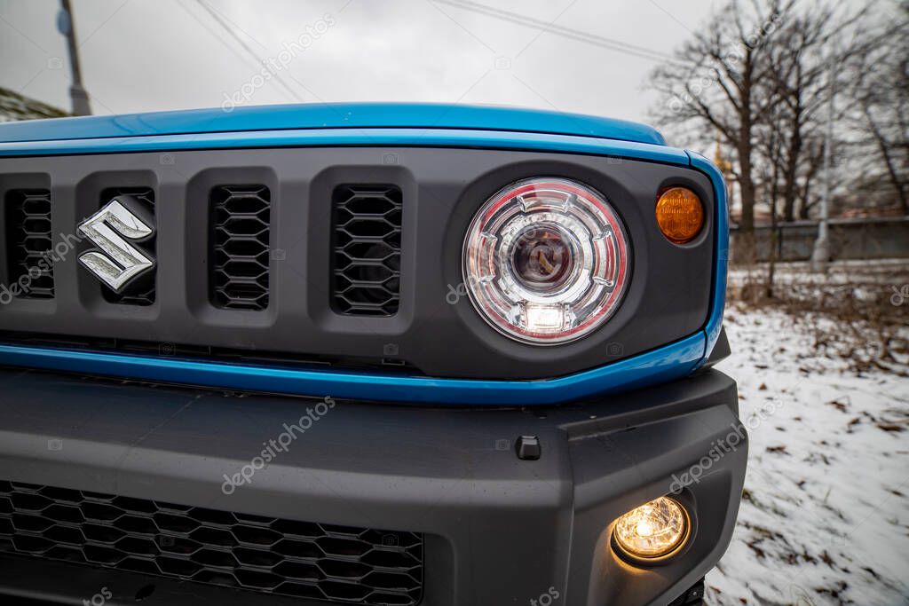 MOSCOW, RUSSIA - JANUARY 24, 2020: Headlight headlamp of new mini SUV Suzuki Jimny Static Photos in winter forest. new design of compact SUV Suzuki Jimny close-up..