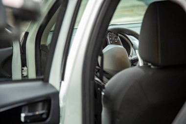 Direksiyon ve arka kapıdan görülen yeni lüks SUV 'un boş sürücü koltuğu. seçici odak.