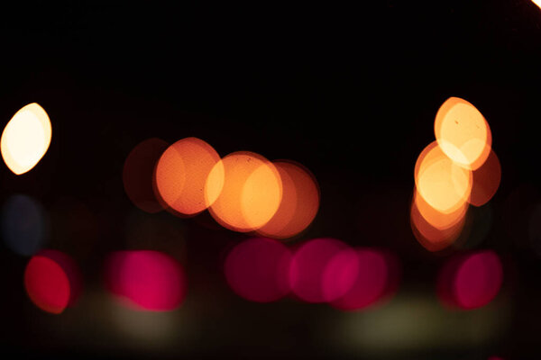 Abstract glare of light with bokeh in blur on a black background. texture,night city lights and cars in blur