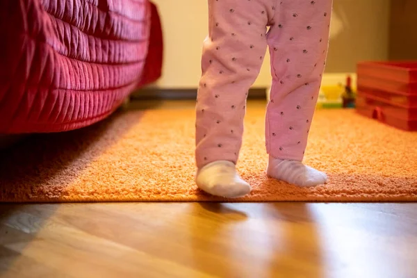 Las piernas de un niño pequeño están caminando alrededor de la habitación. concepto de primeros pasos babys. sin cara — Foto de Stock