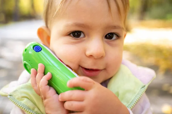 Close up of portrait of cute toddler playing talking on a toy phone — Stock Fotó