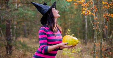 Sarı balkabağı tutan güzel genç kadın, cadılar bayramı