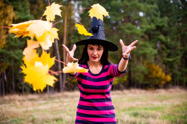 마녀는 숲에서 나뭇잎을 던진다 할로윈 코스튬 마술사인 — 스톡 사진