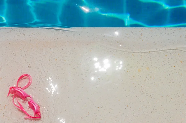 Occhiali da nuoto rosa a bordo piscina — Foto Stock