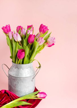 dikey bahar kompozisyonu, pembe pastel arka plan, çerçeve, sınır üzerinde bir vazoda lale düzenlemeleri, bir olay için çiçekli güzel kart Grafik Kaynaklar, boşluk kopyalama .