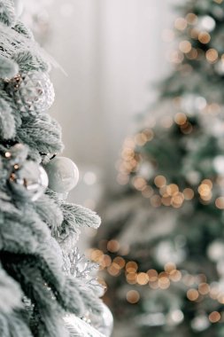Noel arkaplanı çok az. Arka planda bulanık bokeh ışıkları olan toplarla süslenmiş bir Noel ağacı. Baner, tatil kartı, maket. Yeni yıl 2021. Yumuşak seçmeli odak, alanı kopyala.