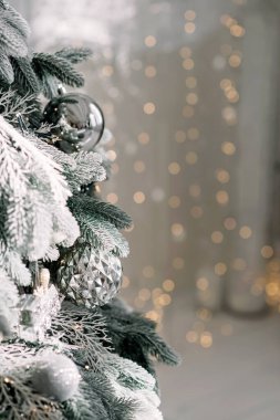 Noel arkaplanı çok az. Arka planda bulanık bokeh ışıkları olan toplarla süslenmiş bir Noel ağacı. Baner, tatil kartı, maket. Yeni yıl 2021. Yumuşak seçmeli odak, alanı kopyala.