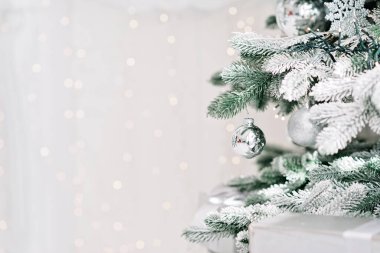 Noel arkaplanı çok az. Arka planda bulanık bokeh ışıkları olan toplarla süslenmiş bir Noel ağacı. Baner, tatil kartı, maket. Yeni yıl 2021. Yumuşak seçmeli odak, alanı kopyala.