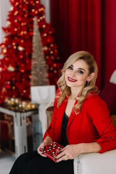 Schöne Frau Rot Mit Weihnachtsschmuck Den Händen Vor Dem Hintergrund — Stockfoto
