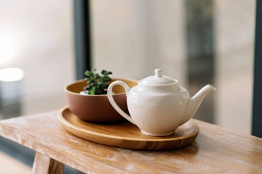 Mutfak gereçleri, çaydanlık, kahve demliği, ahşap tepside. Erken kahvaltı. Yumuşak seçici odak.