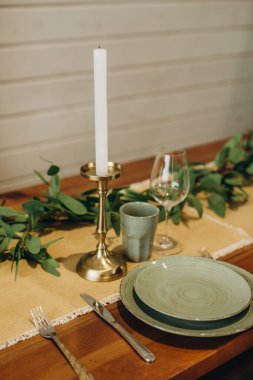 Çatı katı yemek masası çiçekler, mumlar ve otlarla süslenmiş. Yumuşak seçici odak.