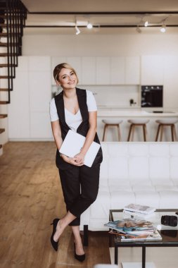 Güzel, şık, modaya uygun bir iş kadını elinde dizüstü bilgisayarı olan bir blog yazarı evinde rahat bir ortamda çalışıyor. Yumuşak seçici odaklanma, odaklanma kaybı, sanat gürültüsü.