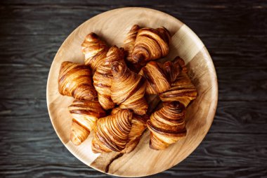 Taze pişmiş kruvasan. Sıcak kokulu kruvasanlar ve ahşap bir stantta yuvarlanmalar. Fransız ve Amerikan hamur işleri tüm dünyada popülerdir..