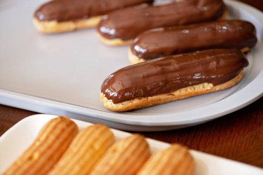 Fransız tatlı eklerleri ya da koyu çikolata kaplı profiteroller. Kremalı ve soslu hamur tatlısı. Yumuşak seçici odak.