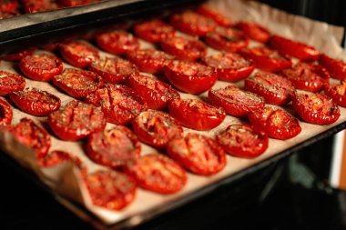 Fırında deniz tuzu ve İtalyan otlarıyla ev yapımı kurutulmuş domatesler. Yumuşak seçici odak.