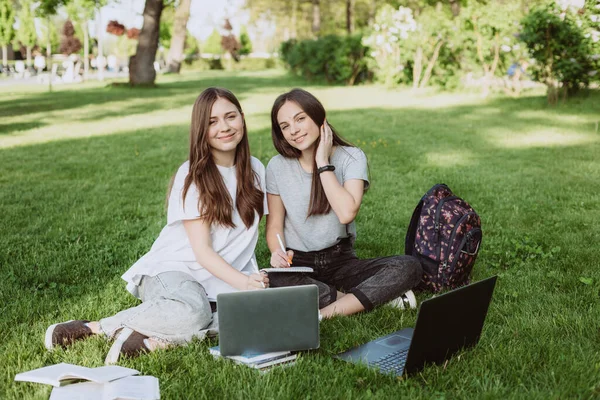 Две Студентки Сидят Парке Траве Книгами Ноутбуками Учатся Готовятся Экзаменам — стоковое фото