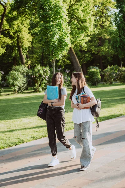 在一个阳光灿烂的温暖的日子里 两个笑容满面的女学生在校园里散步聊天 软性选择性重点 — 图库照片