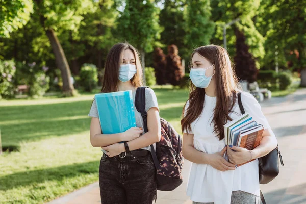 Twee Studentmeisjes Met Beschermende Medische Maskers Lopen Praten Campus Afstandsonderwijs — Stockfoto