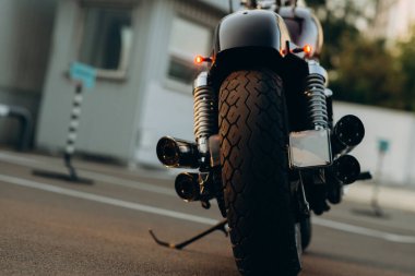 Otoparkta motosiklet, dikiz aynası. Lastik izleri ve krom egzoz boruları. Özel yapım krom parçalı motosiklet. Yumuşak seçici odak.