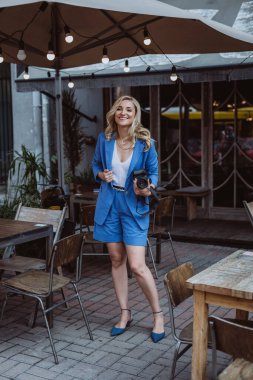 Serbest çalışan güzel bir kadın, blogcu, elinde kamerayla etkili biri. Fotoğrafçı, hobi mesleği. Yumuşak seçici odak.