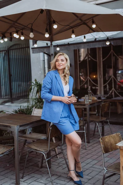 Mavi Takım Elbiseli Güzel Bir Kadını Elinde Akıllı Bir Telefonla — Stok fotoğraf