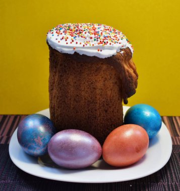 Paskalya pastası ve beyaz tabakta dört boyalı yumurta.