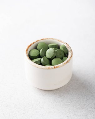 Beyaz arka planda klorella hapları.